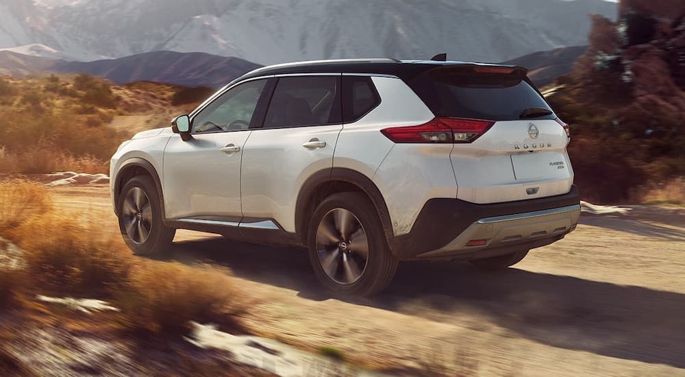 A white 2024 Nissan Rogue is shown from the rear at an angle after leaving a Nissan dealer.