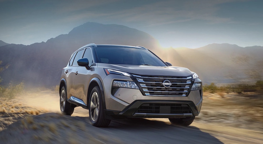 A brown 2024 Nissan Rogue driving on a dusty trail.