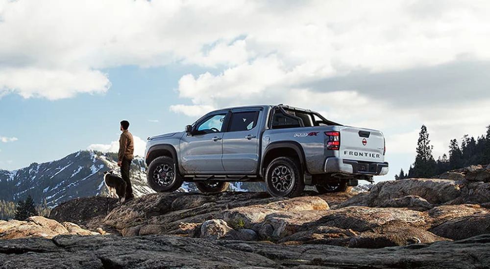 A silver 2024 Nissan Frontier PRO-4X is shown parked off-road.
