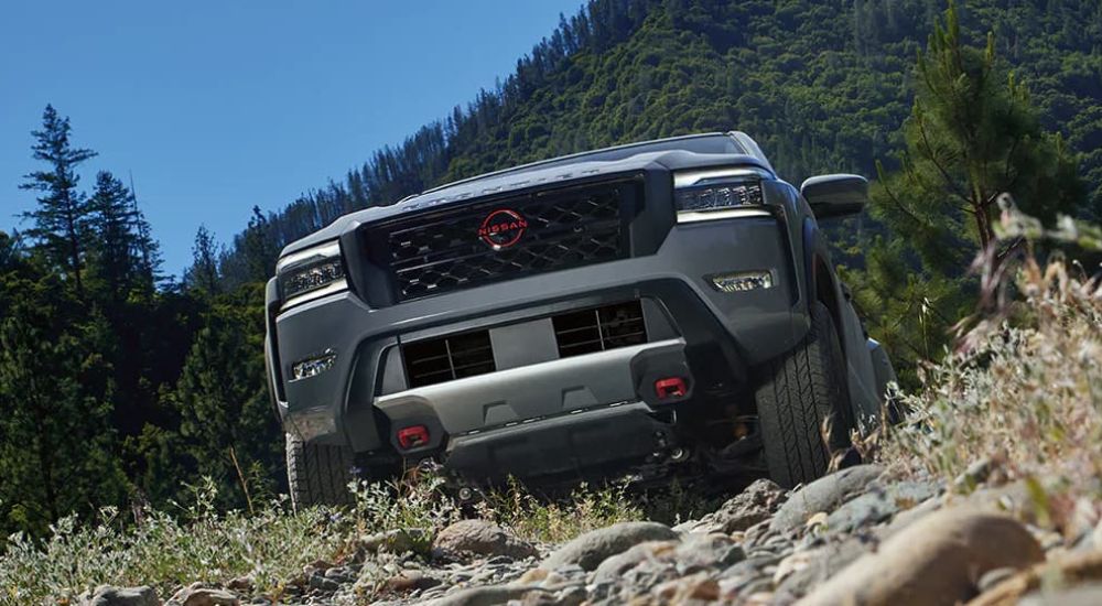 A silver 2024 Nissan Frontier PRO-4X is shown off-roading.