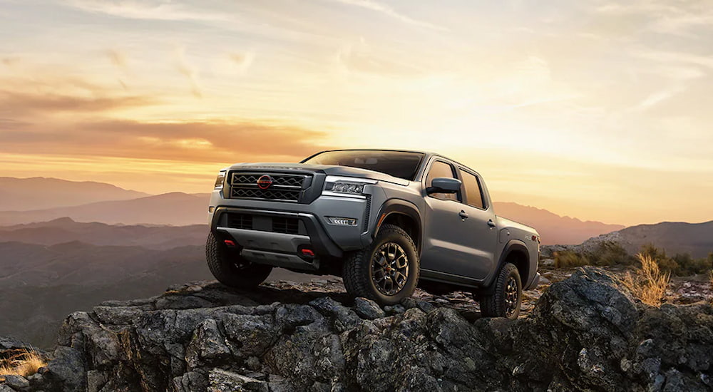 A grey 2024 Nissan Frontier PRO-4X parked off-road on a cliff.