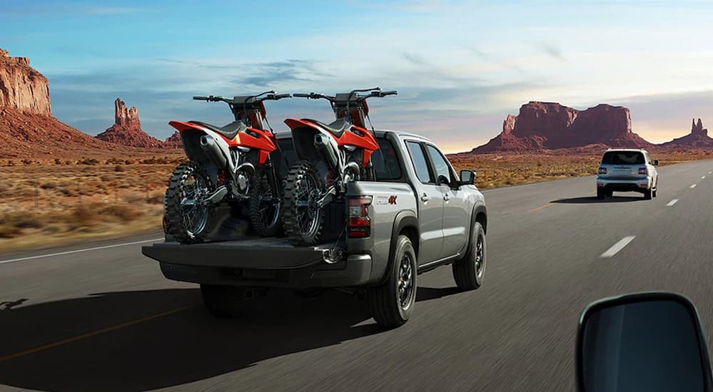 A silver 2025 Nissan Frontier Pro-4x driving on a highway.