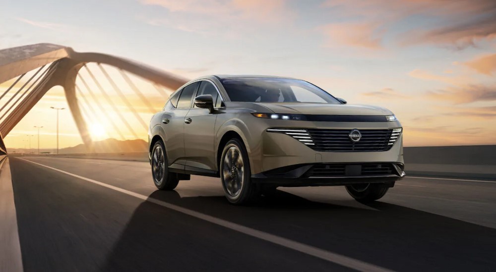 A tan 2025 Nissan Murano for sale driving on a bridge.
