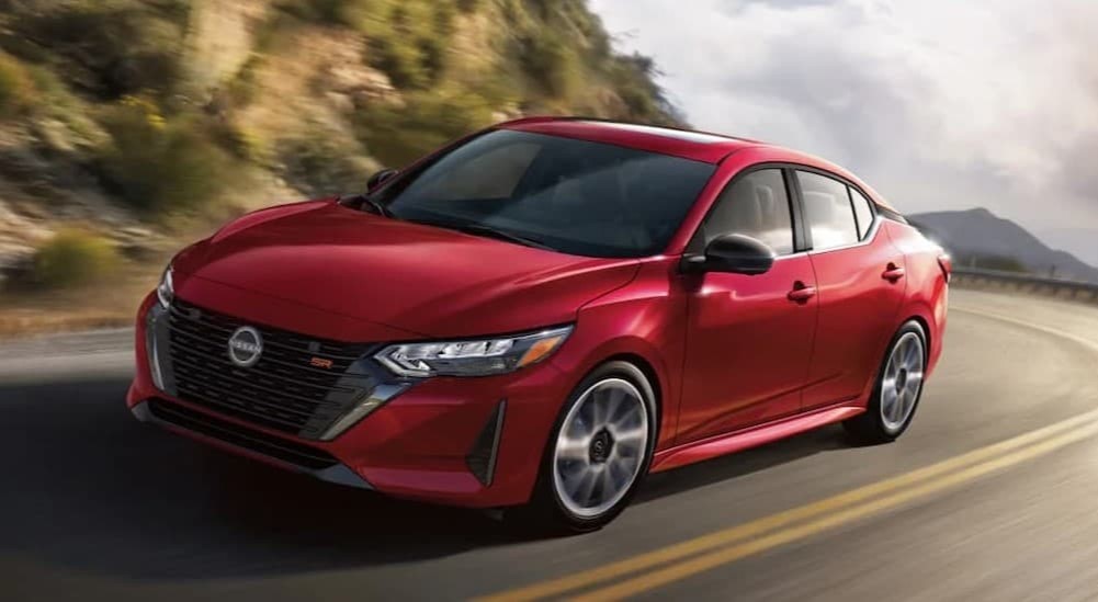 A red 2025 Nissan Sentra driving on a highway.