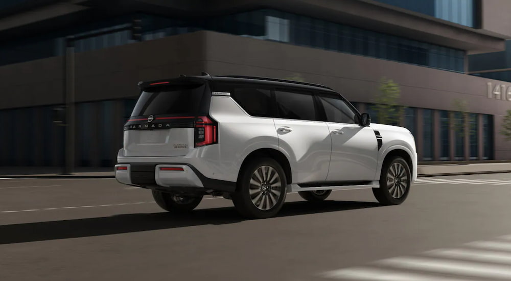 Rear of a white 2025 Nissan Armada driving down a street.