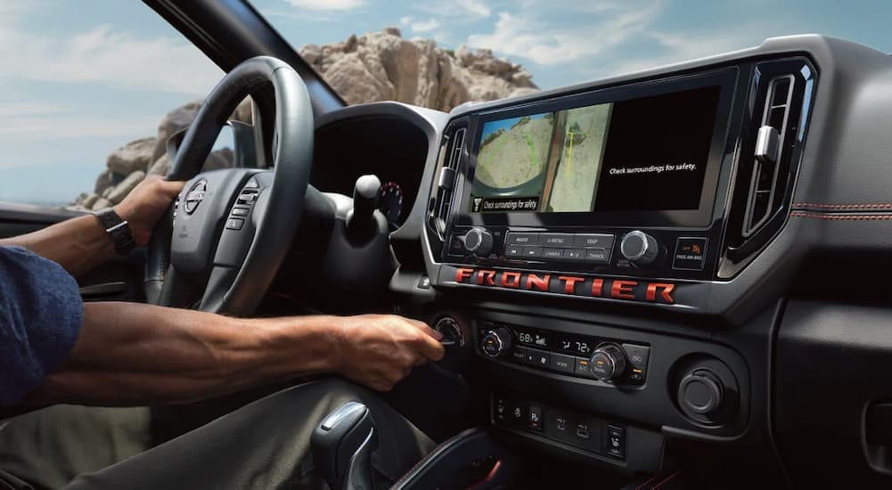 A person driving in a 2026 Nissan Frontier.