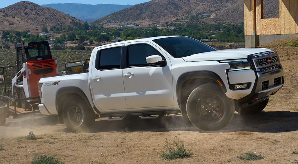 White 2026 Nissan Frontier Pro-4X driving off-road.