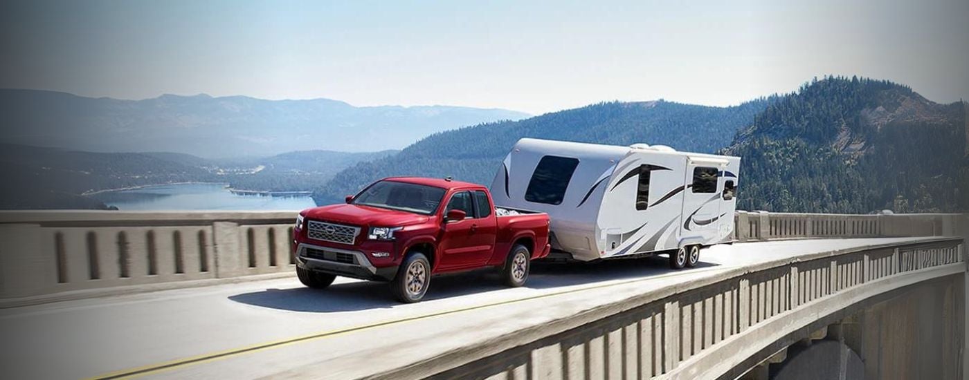 Red 2024 Nissan Frontier towing a camper