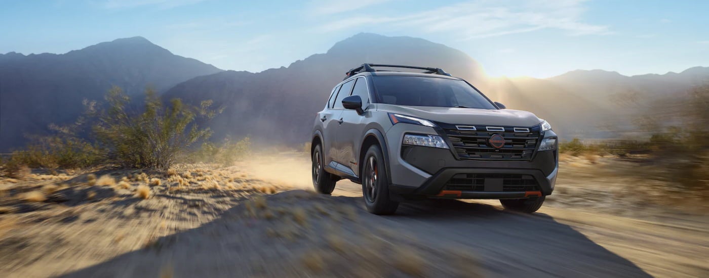 Grey 2026 Nissan Rogue driving off-road.