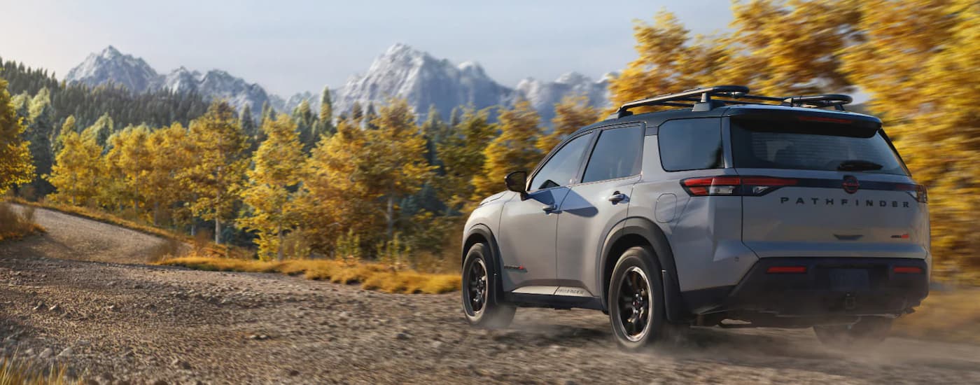 Rear of a grey 2026 Nissan Pathfinder driving off-road.