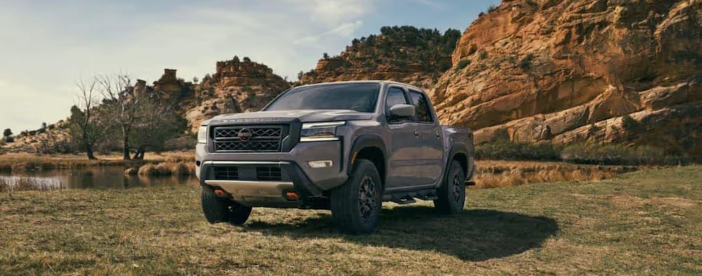 A grey 2022 Nissan Frontier is parked in a field.