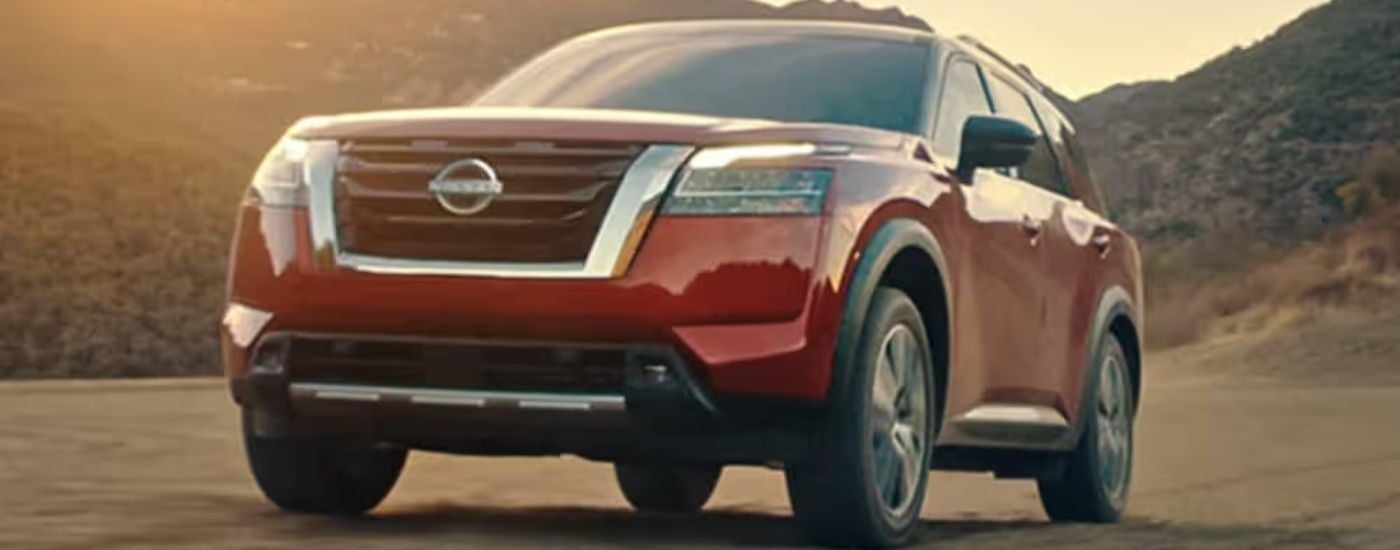 A red 2022 Nissan Pathfinder is shown driving off-road.