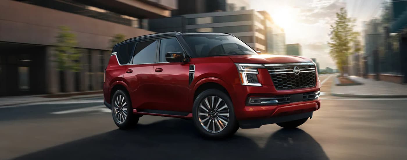 Red 2025 Nissan Armada driving on a city street.