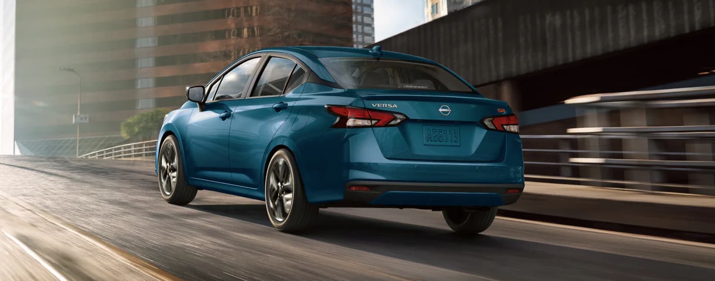 Blue 2025 Nissan Versa driving on a highway.