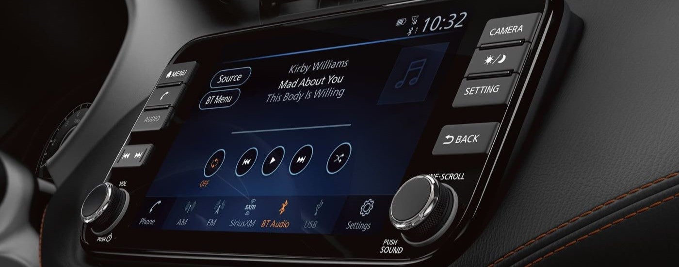 A close-up on an infotainment screen in the black interior cabin of a 2024 Nissan Kicks for sale.