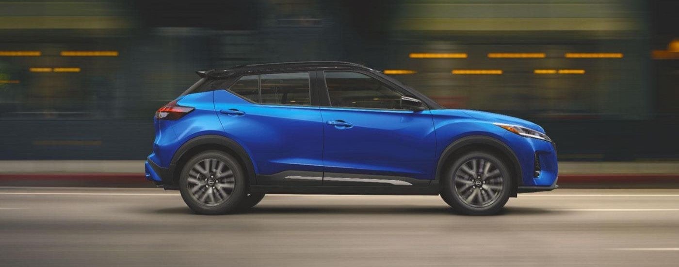 Side angle view of a blue 2024 Nissan Kicks driving through a tunnel.