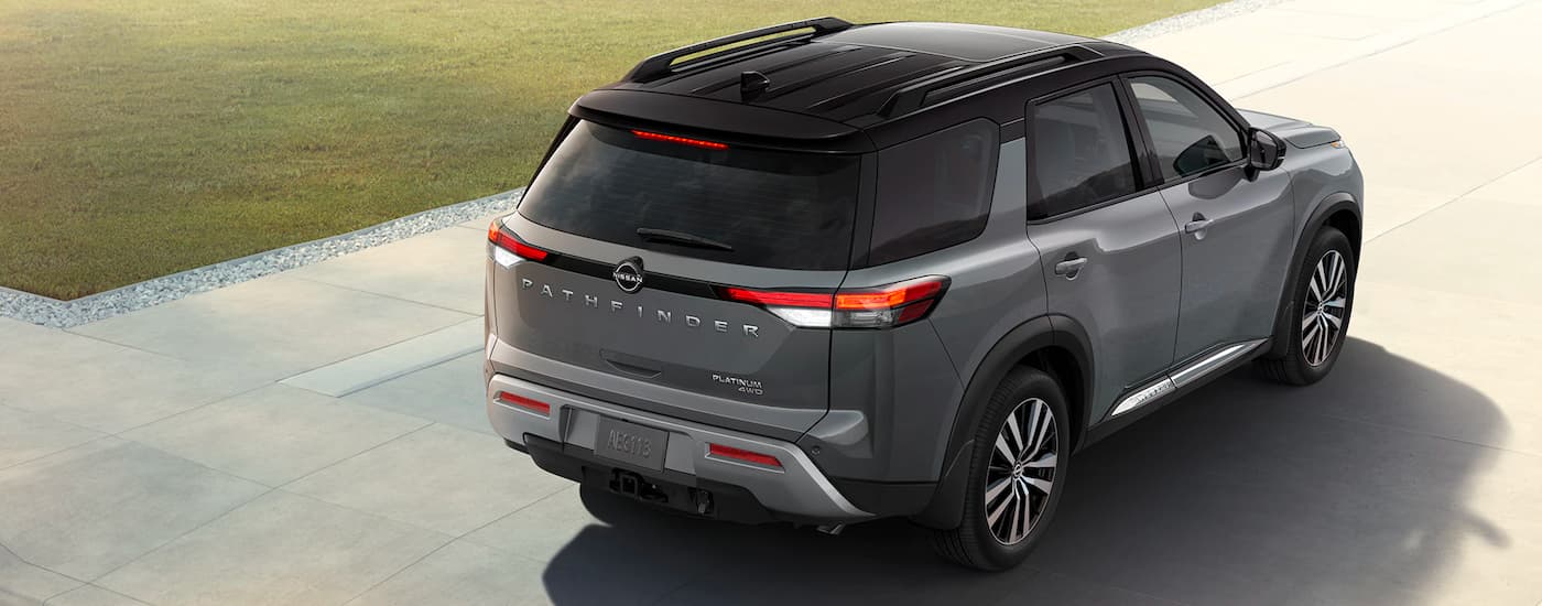 A rear view of a grey 2023 Nissan Pathfinder Platinum parked on a driveway.