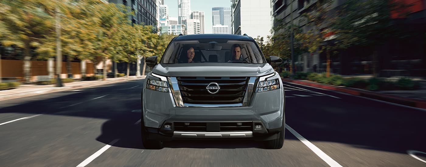 Front of a grey 2026 Nissan Pathfinder driving in a city.