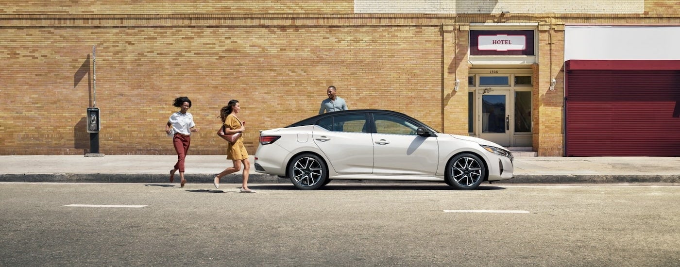 Side of a white 2025 Nissan Sentra parked by a curb.