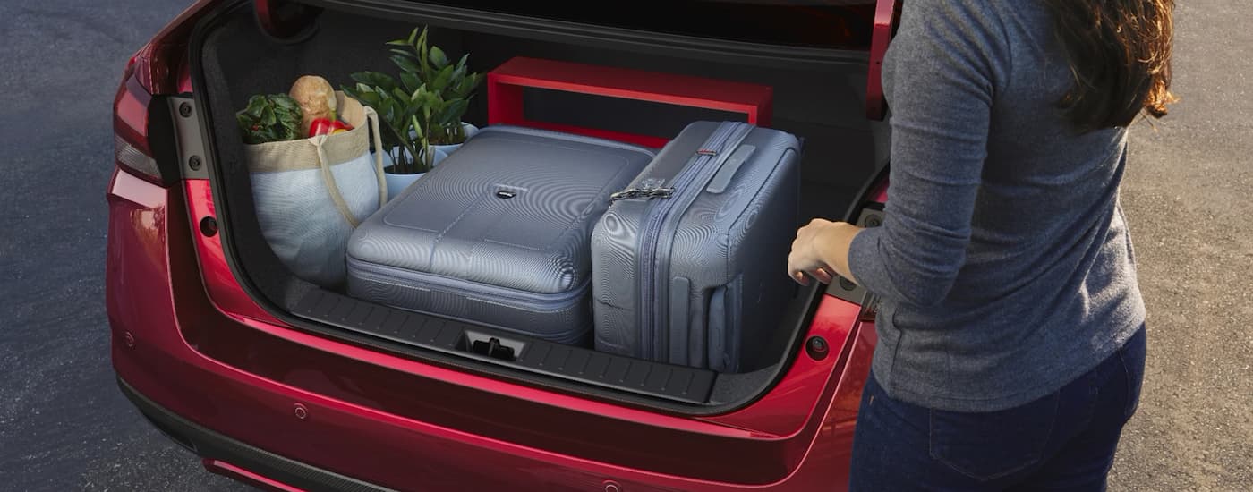 A red 2023 Nissan Versa's trunk is shown full of groceries.